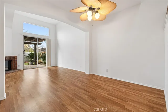 a view of empty room with wooden floor and fireplace