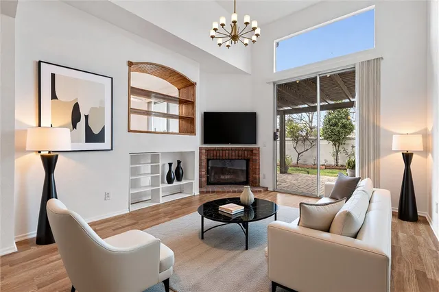 a view of an empty room with wooden floor fireplace and a window