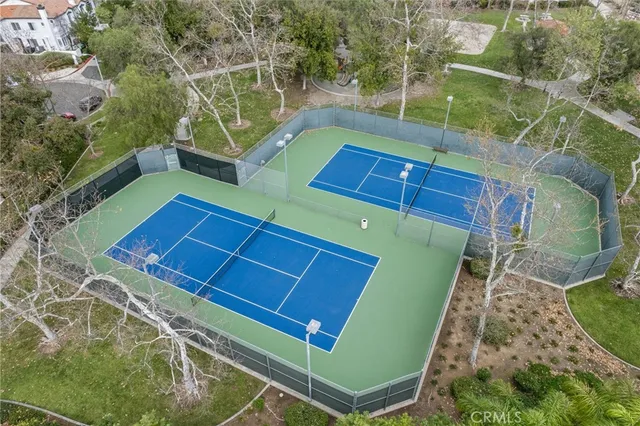 an aerial view of a house with outdoor space and trees all around