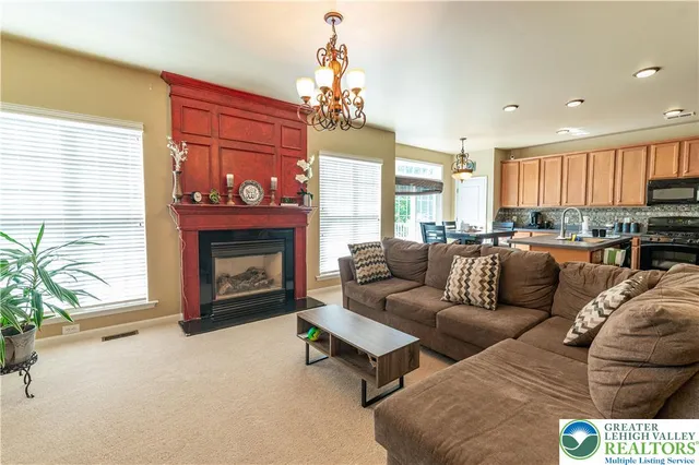 a living room with furniture a fireplace and a chandelier