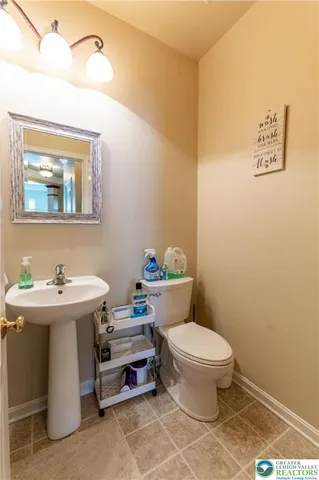 a bathroom with a toilet a sink and mirror