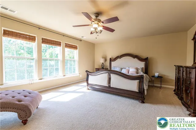 a spacious bedroom with a large bed and a chandelier