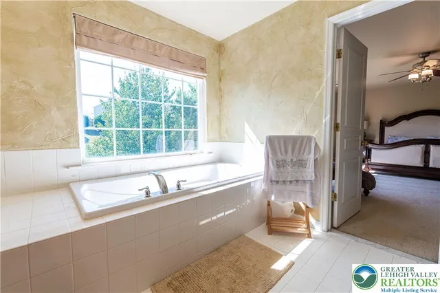 a spacious bathroom with a tub sink and mirror