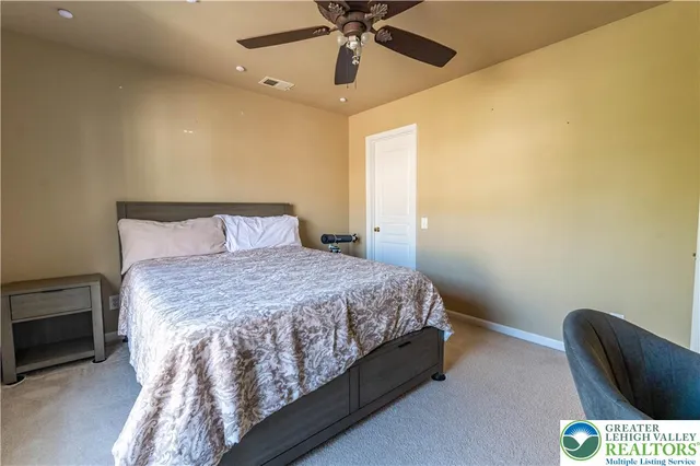 a spacious bedroom with a bed and a chandelier