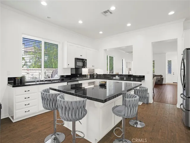 a large kitchen with kitchen island a large counter top space and stainless steel appliances