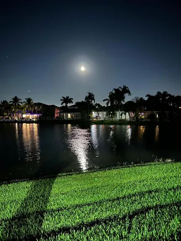 an aerial view of a house with a yard and lake view