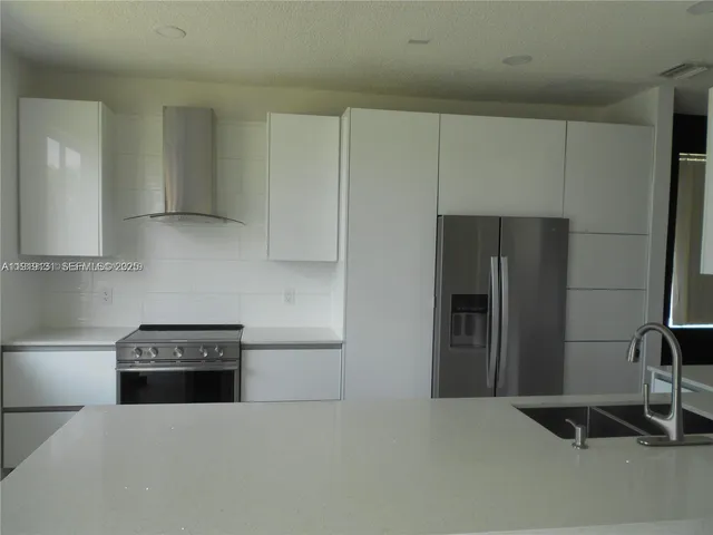 a kitchen with a refrigerator and a stove