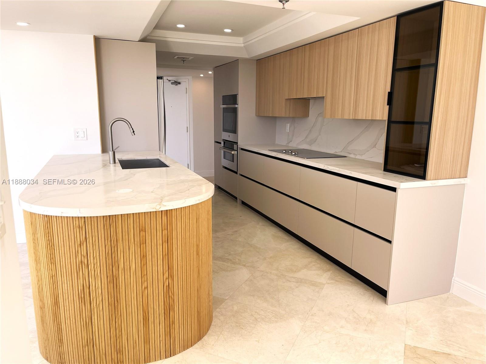 520 Brickell Key Drive, Unit UPH03 Miami, FL 33131 - Photo 19 of 33 a kitchen with kitchen island a sink stainless steel appliances and cabinets