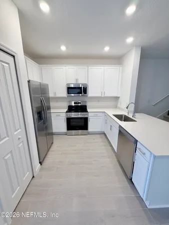 a kitchen with stainless steel appliances a refrigerator sink and stove
