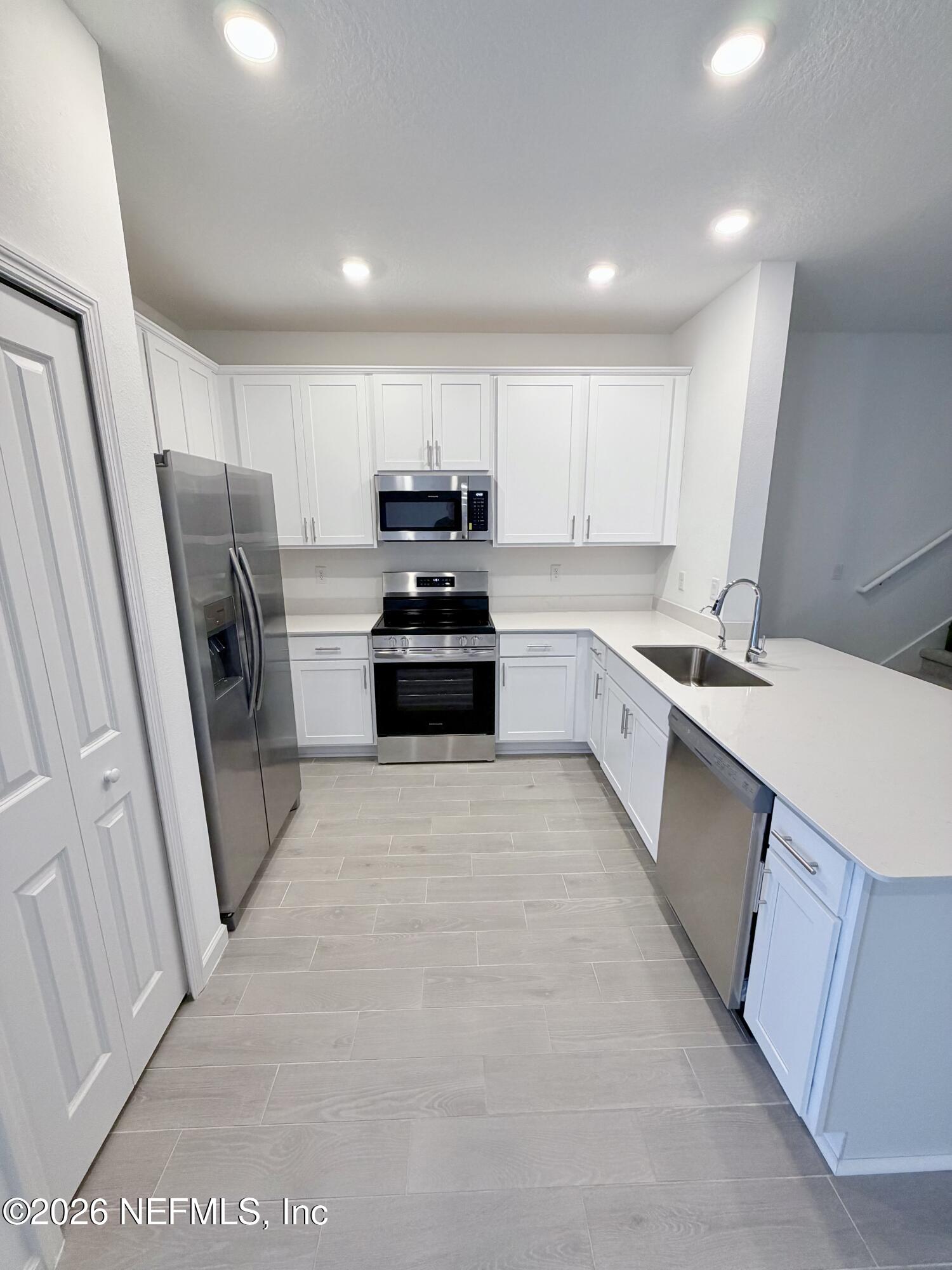 2113 Windward Cay Lane Middleburg, FL 32068 - Photo 9 of 34 a kitchen with stainless steel appliances a refrigerator sink and stove