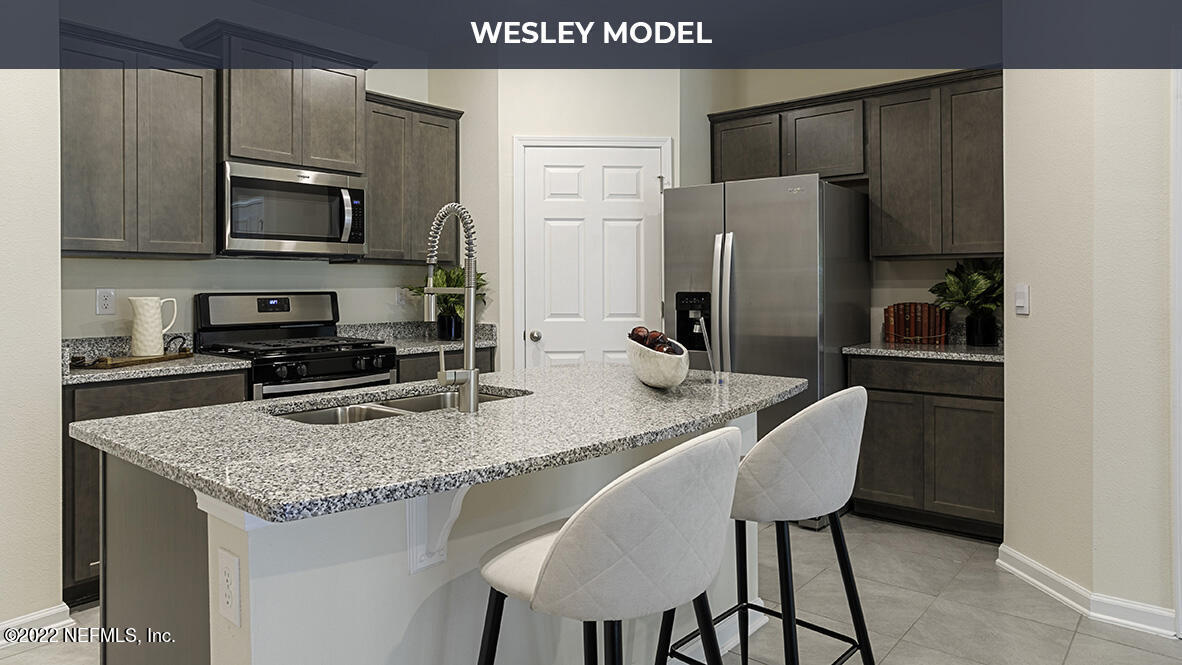 48 Barley Street St. Augustine, FL 32092 - Photo 6 of 37 a kitchen with stainless steel appliances granite countertop a kitchen island a stove a refrigerator a sink a dining table and chairs