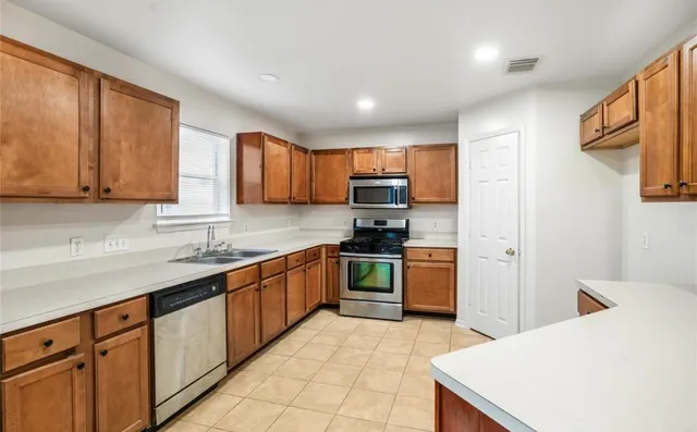 a kitchen with stainless steel appliances granite countertop a refrigerator sink and cabinets