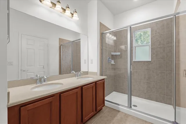a bathroom with a shower sink vanity and mirror