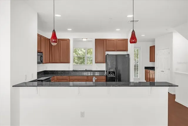 a kitchen with stainless steel appliances granite countertop a stove a sink and a refrigerator