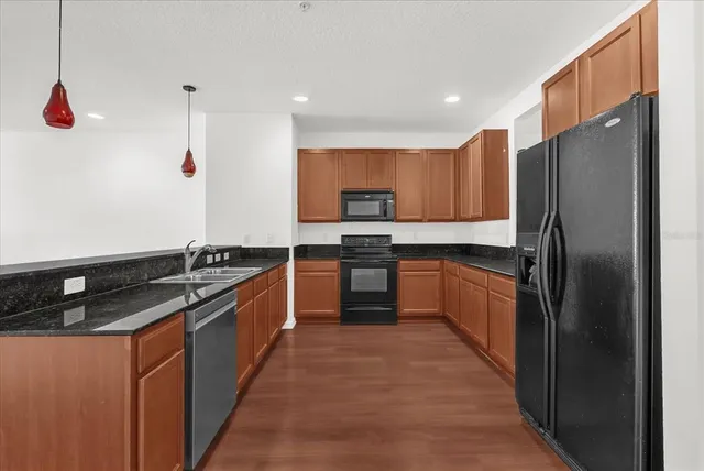 a kitchen with stainless steel appliances granite countertop a stove a sink and a refrigerator