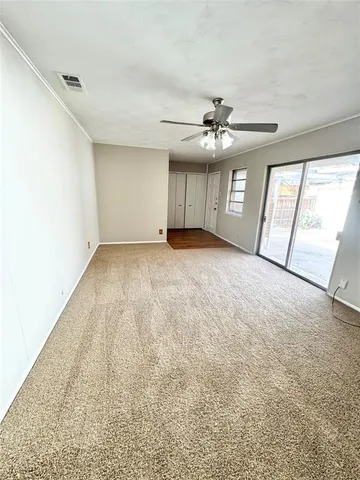 an empty room with windows and ceiling fan