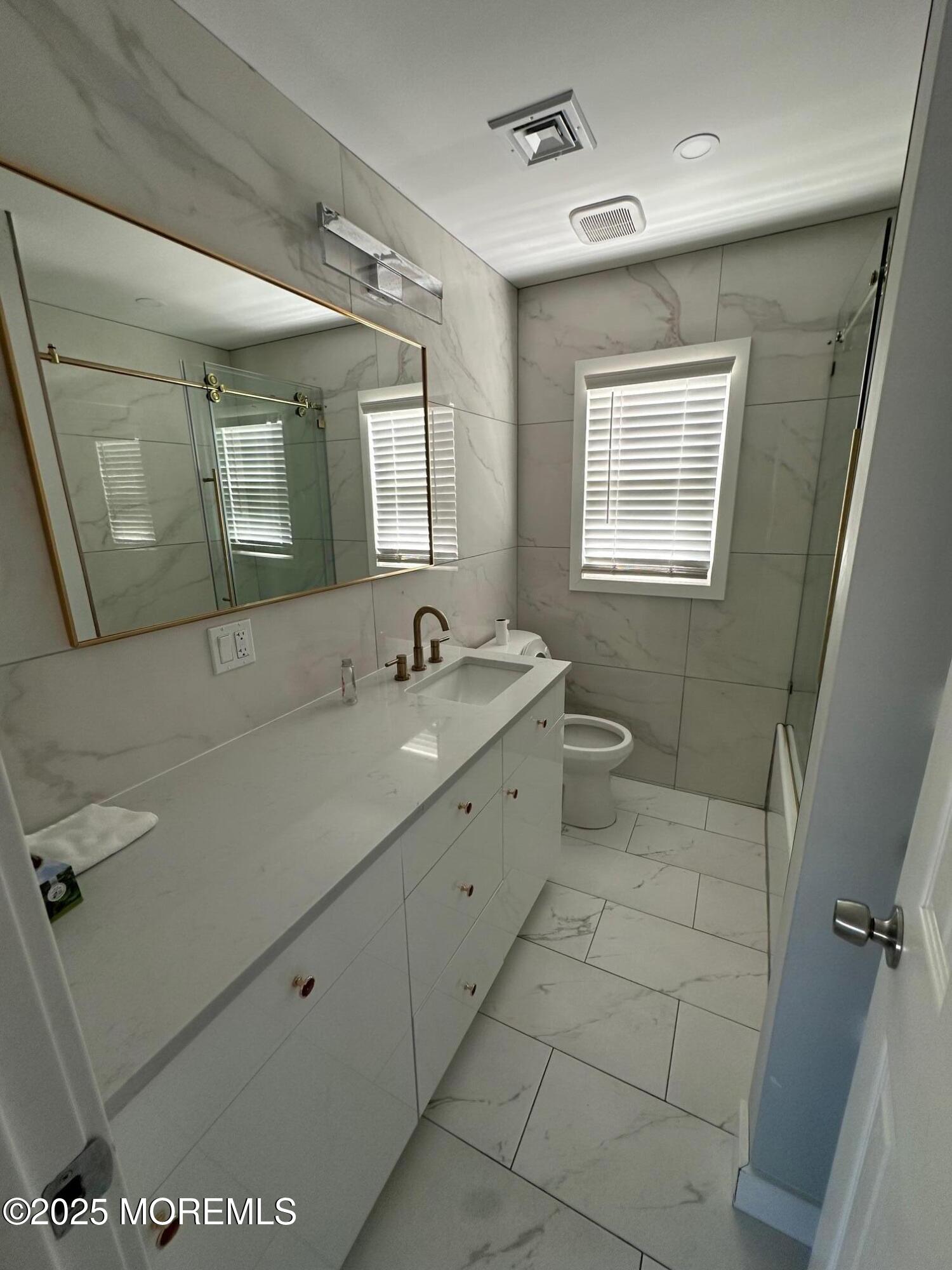 10 Cambell Court, Unit W Deal, NJ 07723 - Photo 11 of 28 a spacious bathroom with a double vanity sink a toilet and a mirror