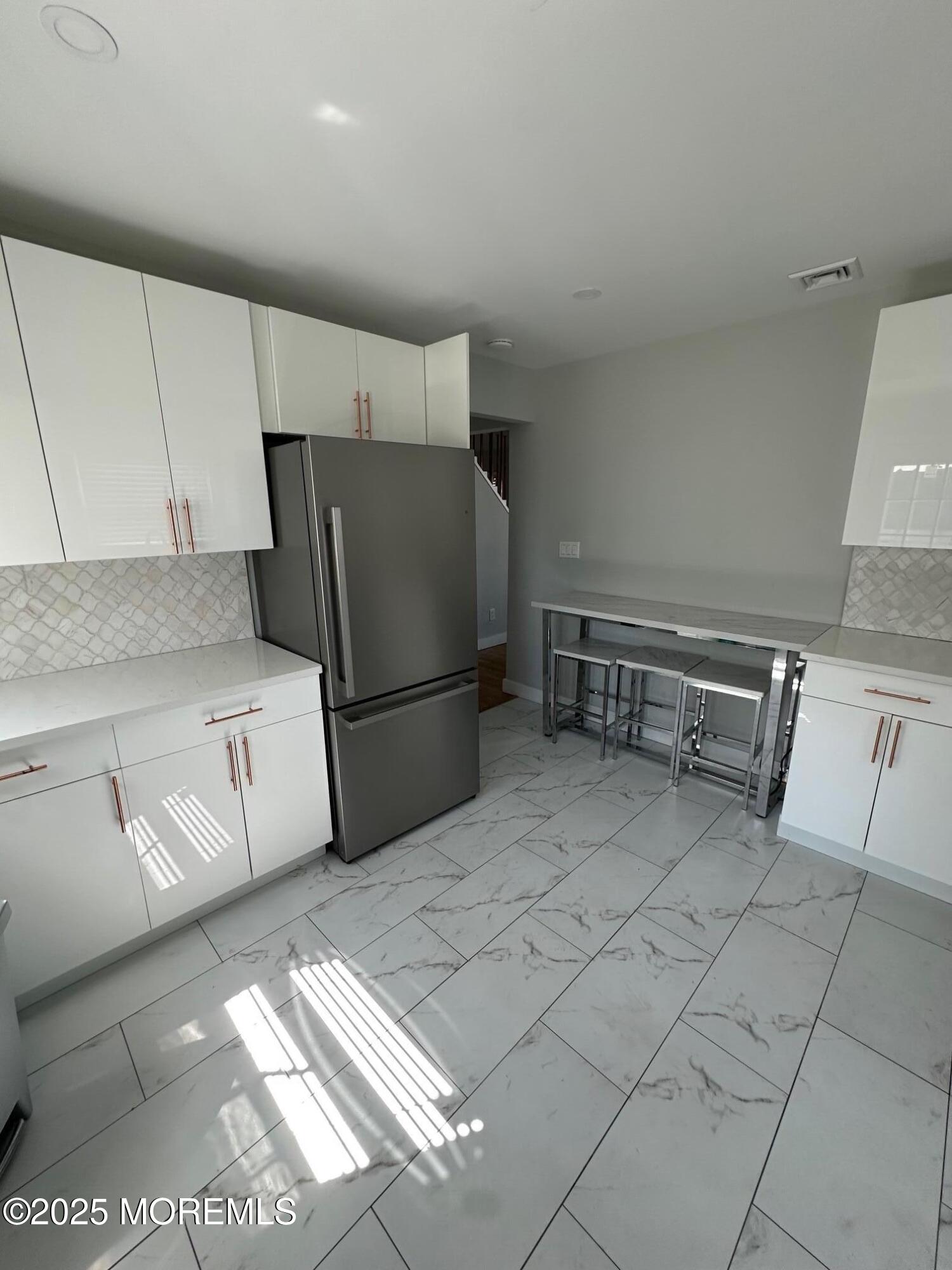 10 Cambell Court, Unit W Deal, NJ 07723 - Photo 14 of 28 a kitchen with stainless steel appliances granite countertop a refrigerator sink and cabinets