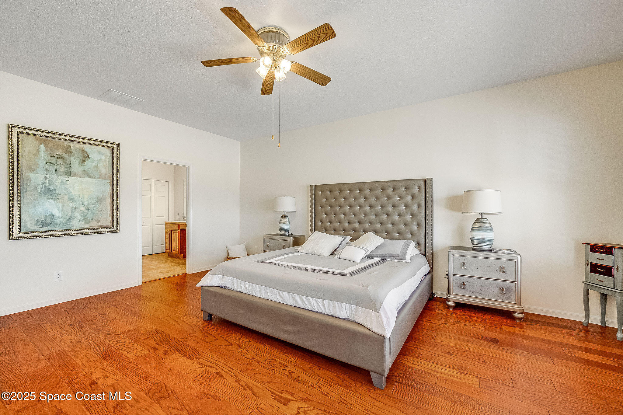 1137 Morgan Circle Northeast Palm Bay, FL 32905 - Photo 18 of 64 a bedroom with a bed and a chandelier