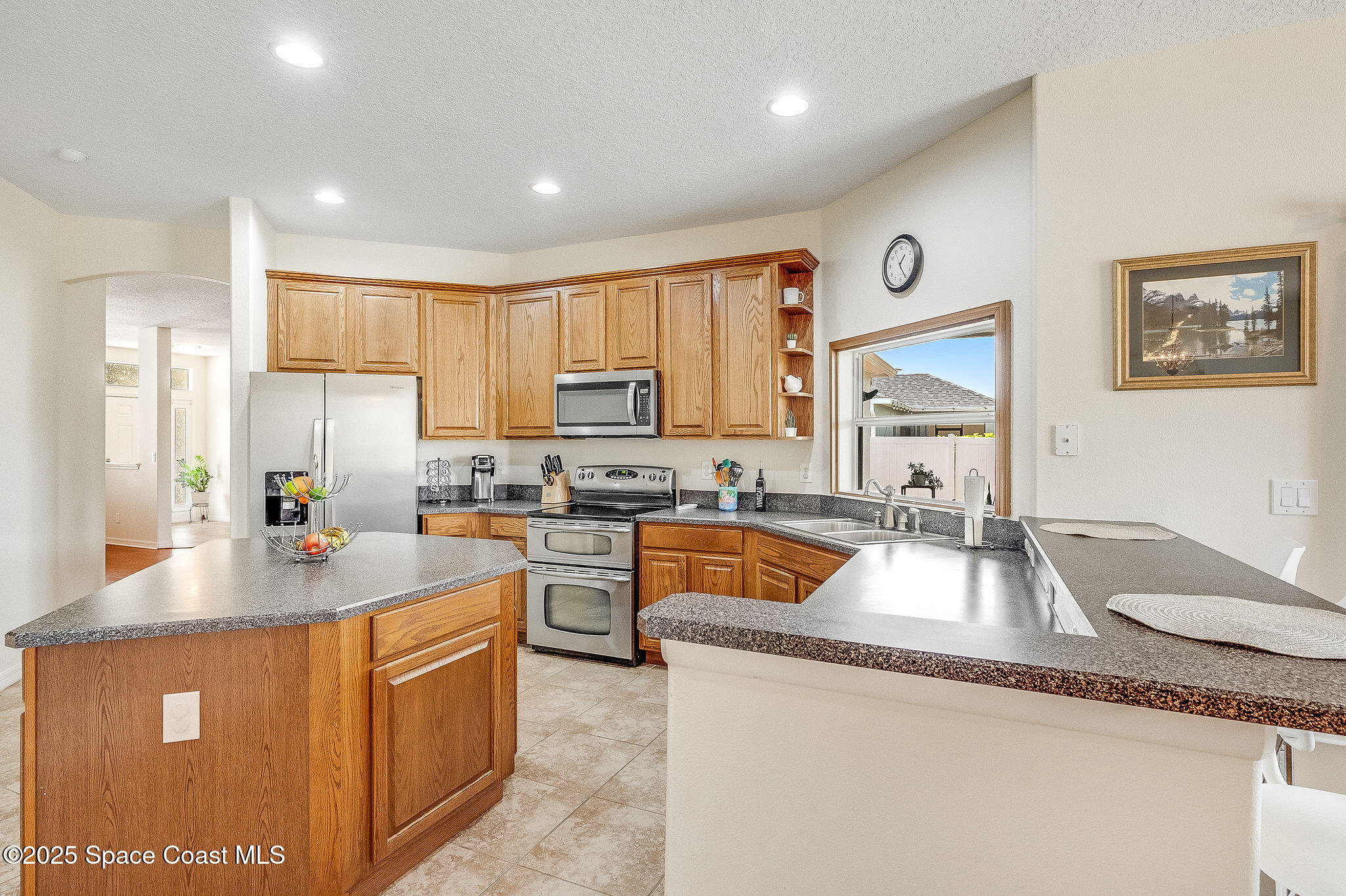 1137 Morgan Circle Northeast Palm Bay, FL 32905 - Photo 29 of 64 a kitchen with stainless steel appliances granite countertop a sink a stove and a refrigerator
