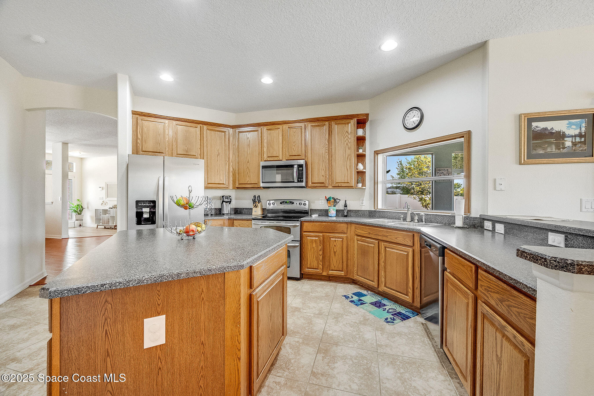 1137 Morgan Circle Northeast Palm Bay, FL 32905 - Photo 30 of 64 a kitchen with stainless steel appliances granite countertop a sink stove and refrigerator