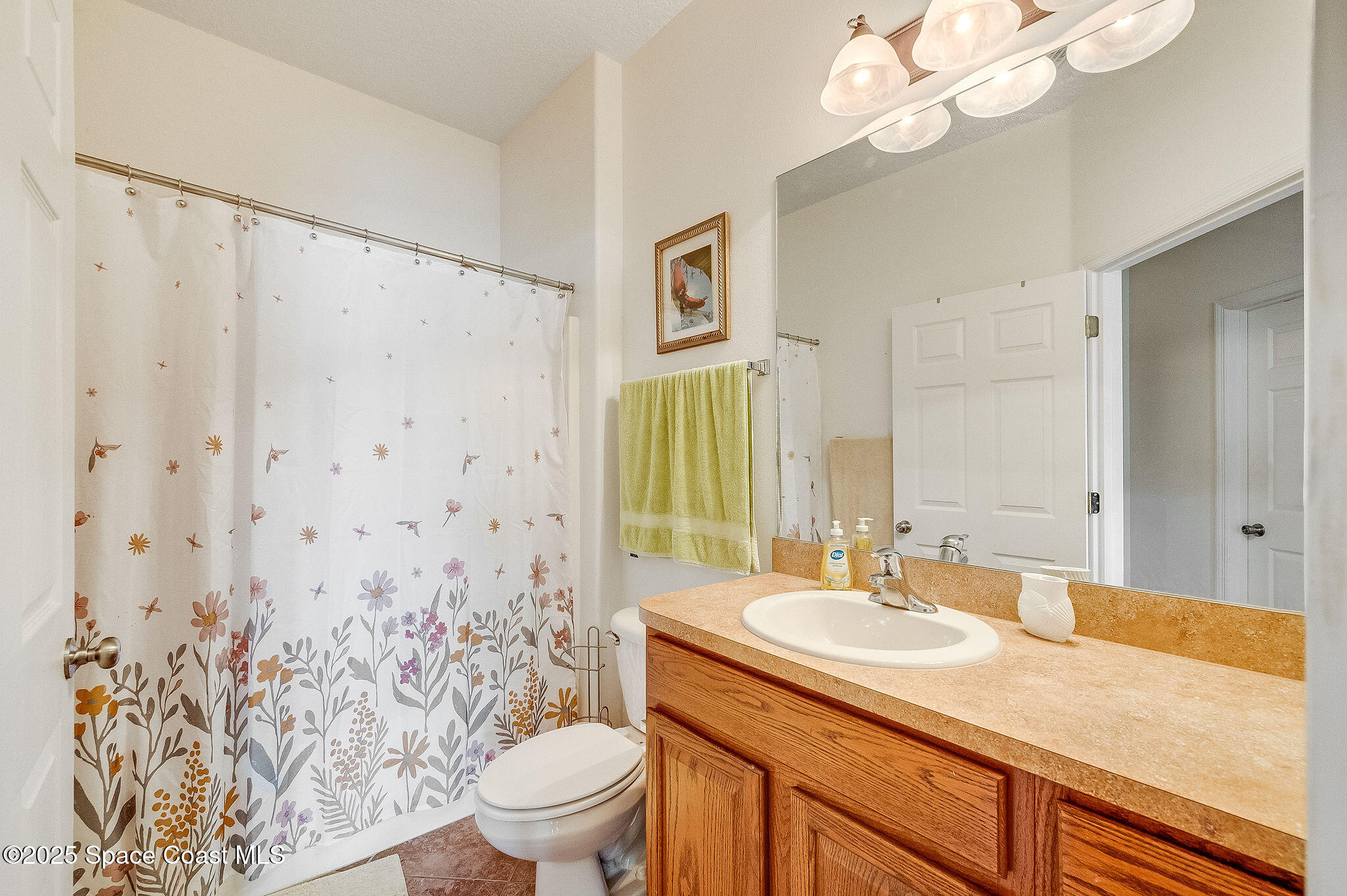 1137 Morgan Circle Northeast Palm Bay, FL 32905 - Photo 44 of 64 a bathroom with a granite countertop sink a toilet and a mirror