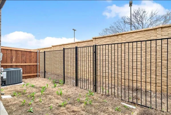 a view of a backyard with floor to ceiling window and wooden fence