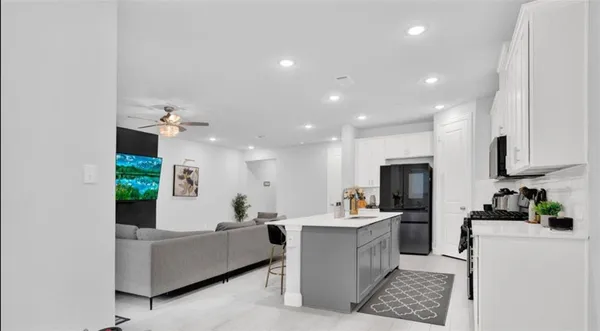 a living room with kitchen island furniture and a chandelier