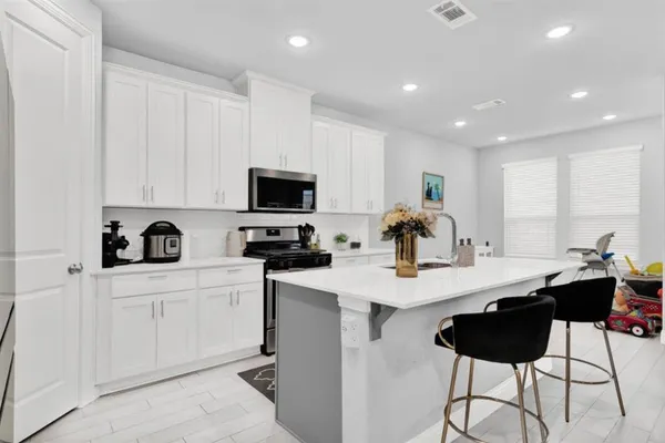 a kitchen with sink a microwave and cabinets