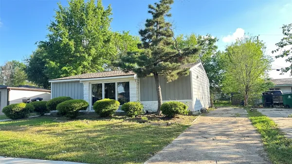 a front view of house with yard and trees around