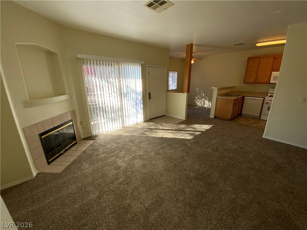 4730 East Craig Road, Unit 1091 Las Vegas, NV 89115 - Photo 4 of 14 A cozy living space features an inviting fireplace and easy access to the adjacent kitchen.