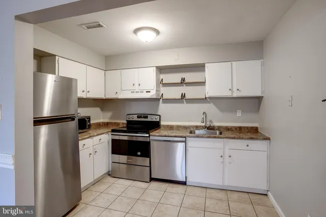 a kitchen with granite countertop white cabinets and white appliances