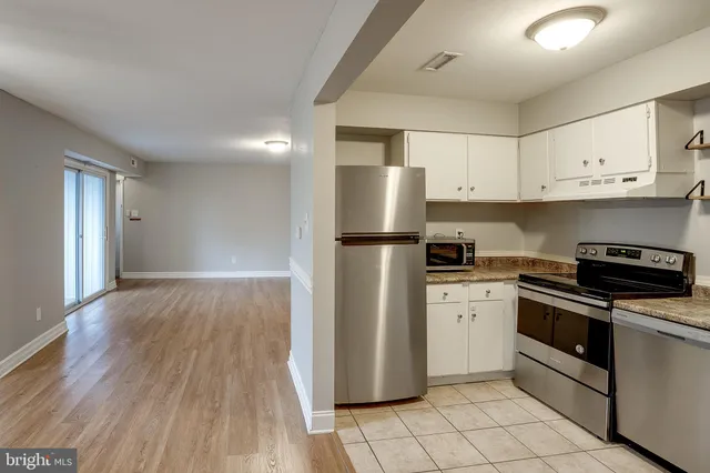a kitchen with a refrigerator sink and cabinets