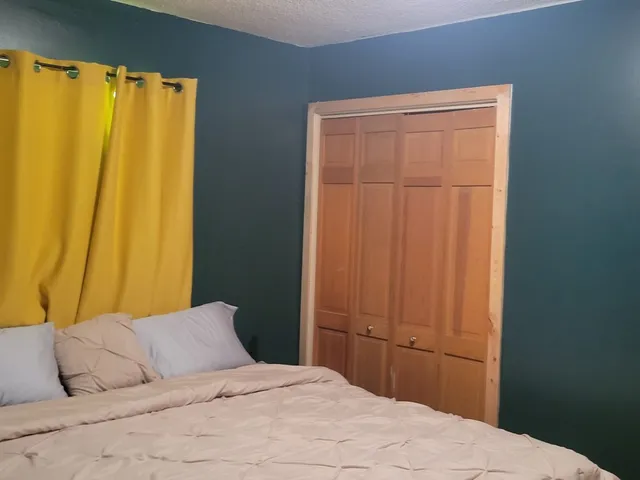 a bedroom with a bed and a window