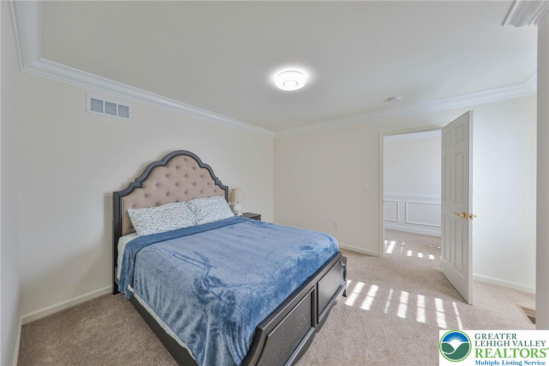 1105 Meco Road Easton, PA 18040 - Photo 68 of 100 Crown molding frames this comfortable bedroom space boasting plush carpeting and neutral walls.