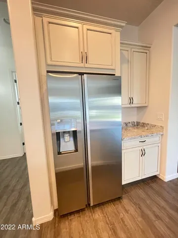 a kitchen with granite countertop stainless steel appliances a refrigerator and cabinets
