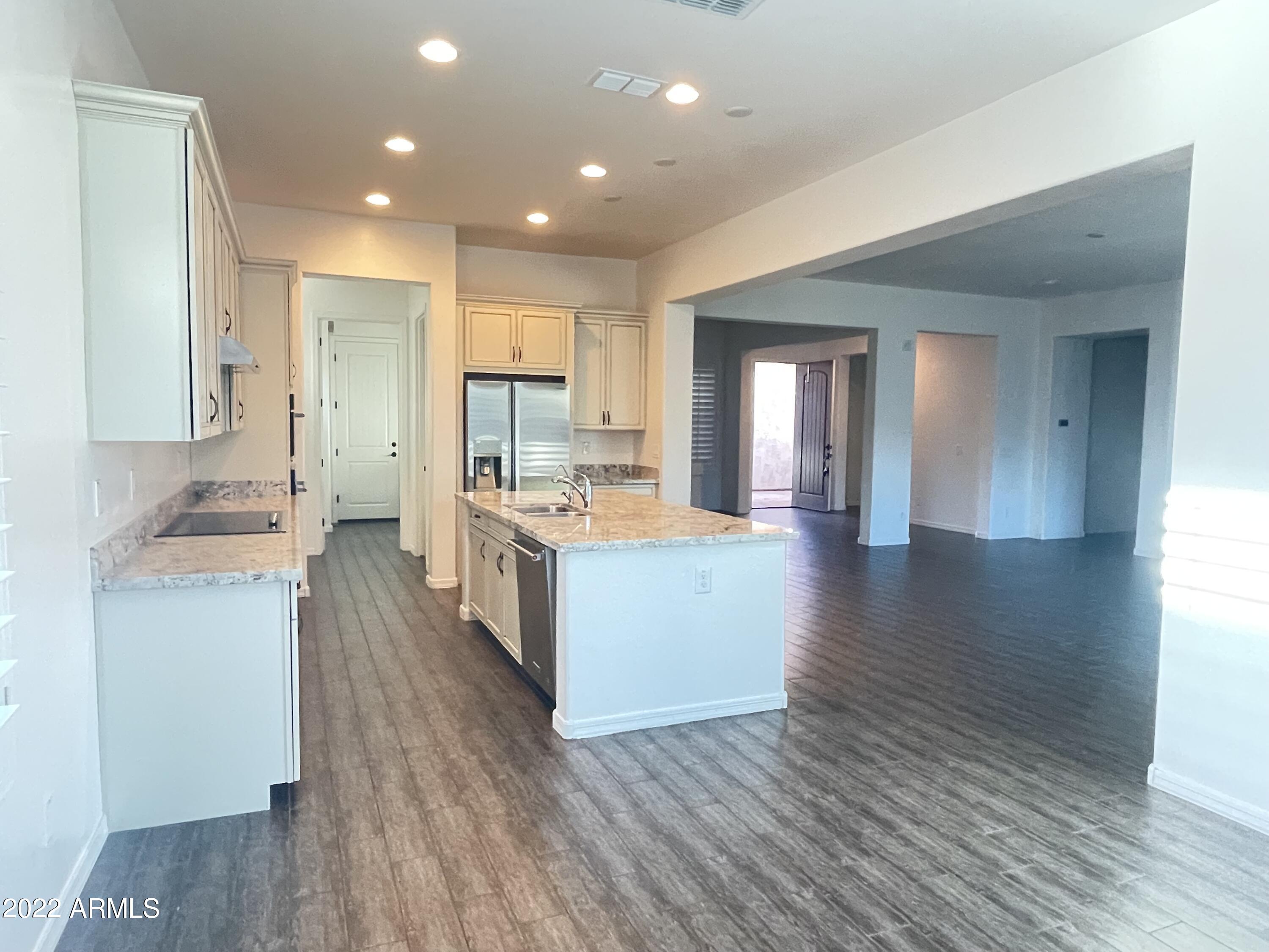 991 East Hampton Lane Gilbert, AZ 85295 - Photo 3 of 13 a large kitchen with stainless steel appliances kitchen island a large counter top and a wooden floors