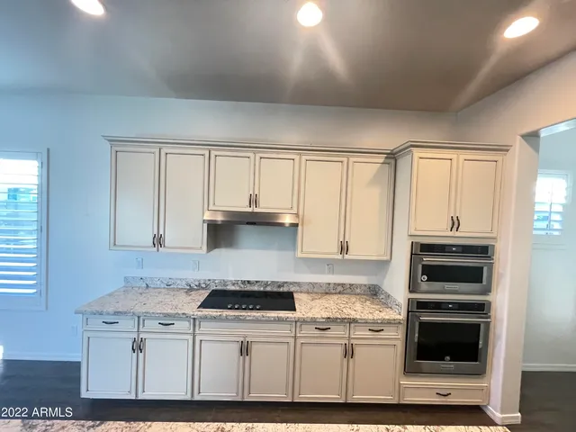 a kitchen with stainless steel appliances granite countertop a stove and white cabinets