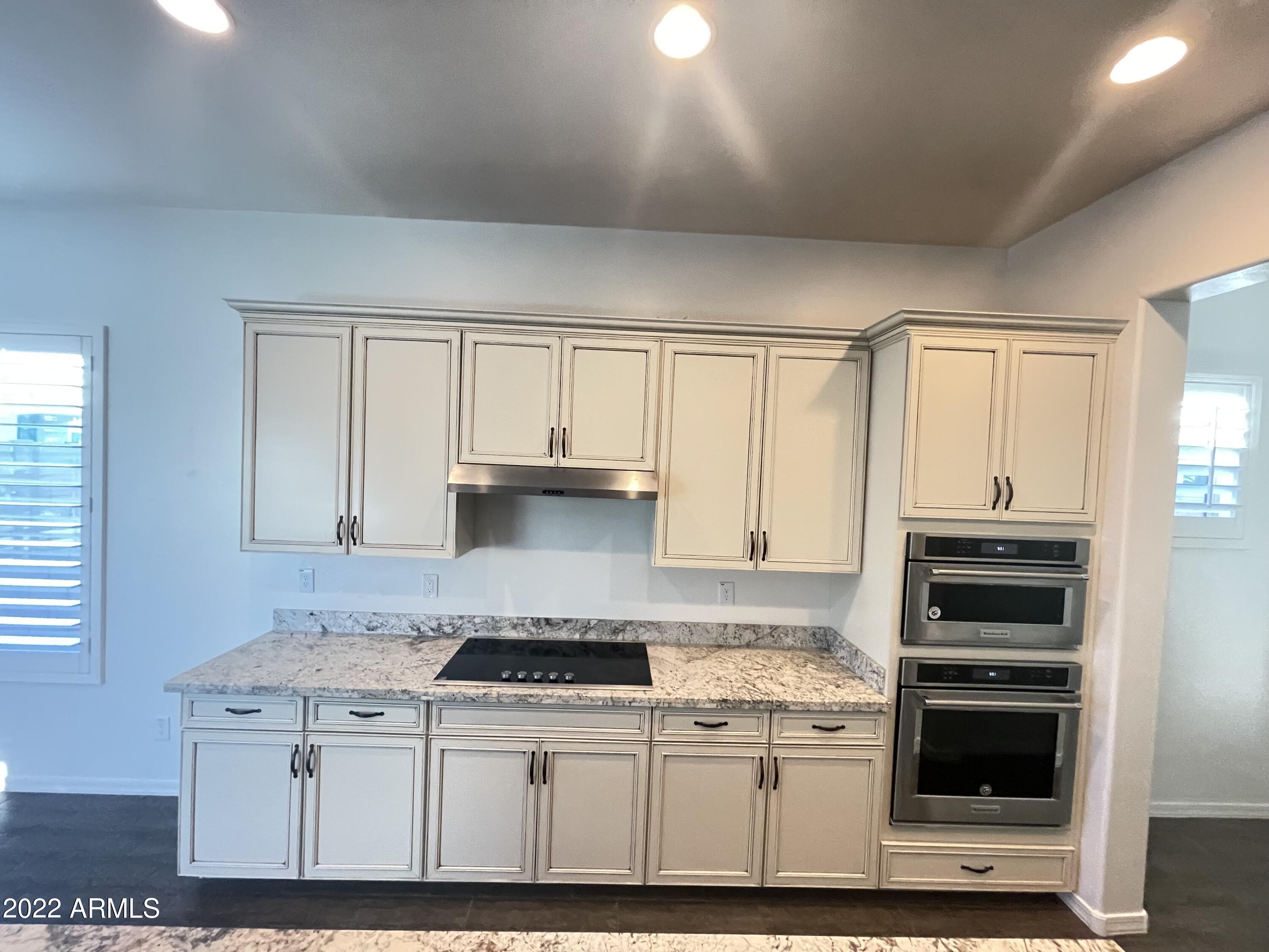991 East Hampton Lane Gilbert, AZ 85295 - Photo 5 of 13 a kitchen with stainless steel appliances granite countertop a stove and white cabinets