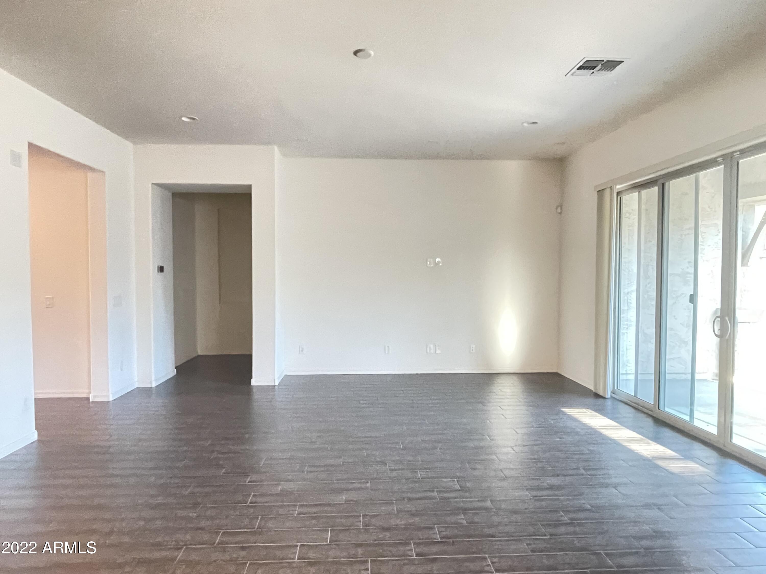 991 East Hampton Lane Gilbert, AZ 85295 - Photo 8 of 13 a view of an empty room with wooden floor and a window