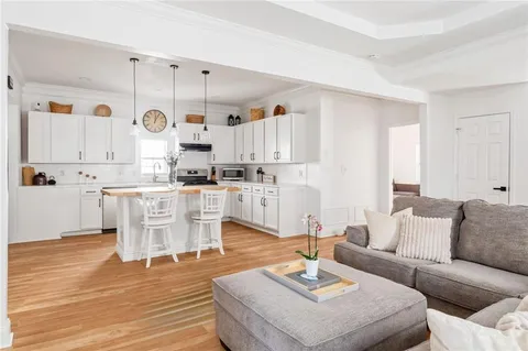 a kitchen with stainless steel appliances granite countertop a sink a stove a refrigerator and island with wooden floor