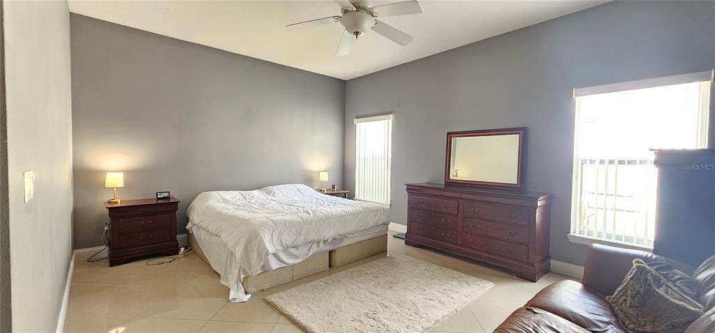 10927 Leader Lane Orlando, FL 32825 - Photo 11 of 29 a bedroom with a bed and a chandelier