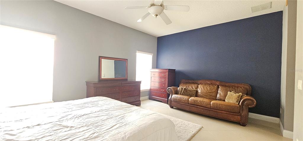 10927 Leader Lane Orlando, FL 32825 - Photo 12 of 29 a bedroom with a bed couch and window