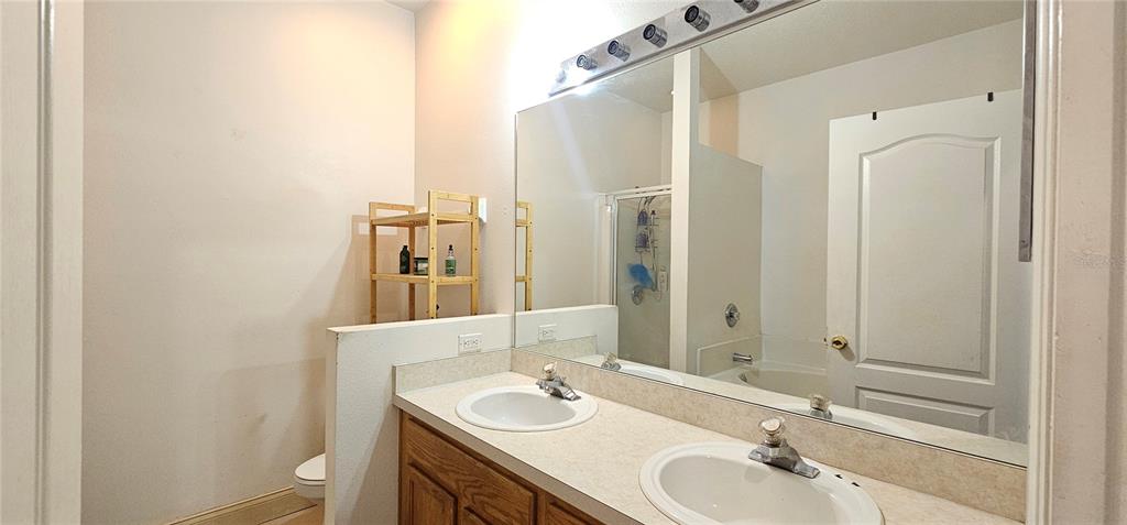 10927 Leader Lane Orlando, FL 32825 - Photo 13 of 29 a bathroom with a granite countertop sink and a mirror