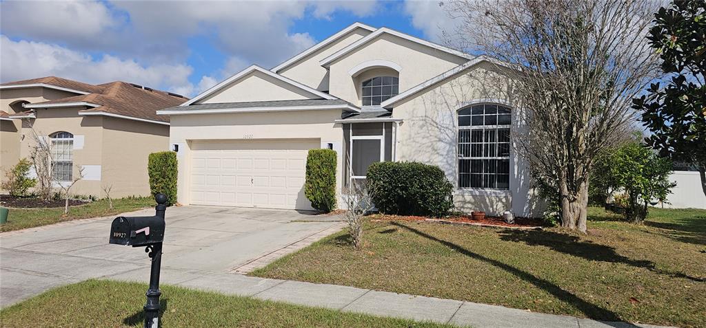 10927 Leader Lane Orlando, FL 32825 - Photo 2 of 29 a front view of a house with garden