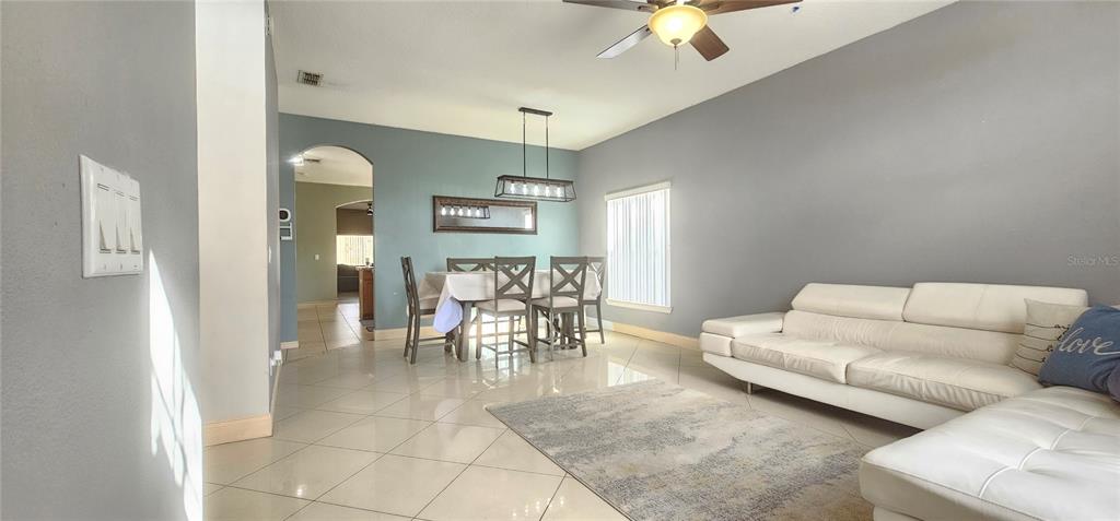 10927 Leader Lane Orlando, FL 32825 - Photo 5 of 29 a living room with furniture and a dining table with kitchen view