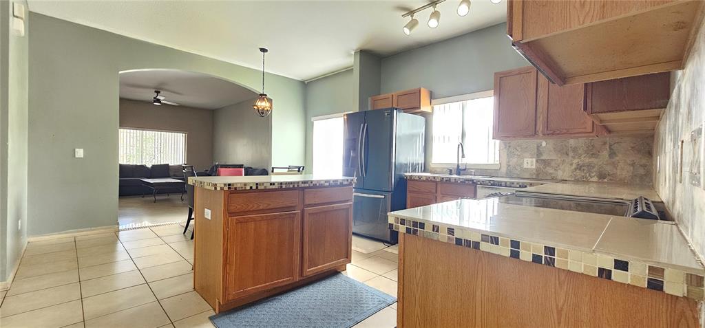 10927 Leader Lane Orlando, FL 32825 - Photo 8 of 29 a large kitchen with kitchen island a large counter top space a sink a window and stainless steel appliances