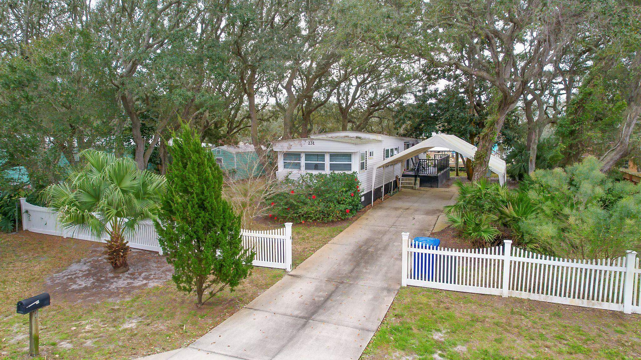 231 Puebla Road St. Augustine, FL 32080 - Photo 4 of 54 View of front of property featuring driveway, a fenced front yard, and view of wooded area