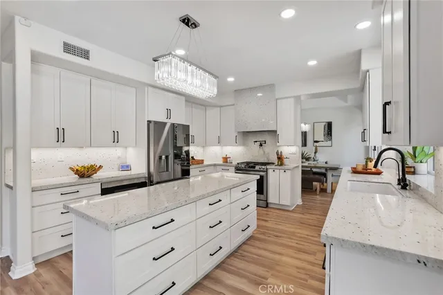 an open kitchen with stainless steel appliances granite countertop a stove oven and a refrigerator with cabinets