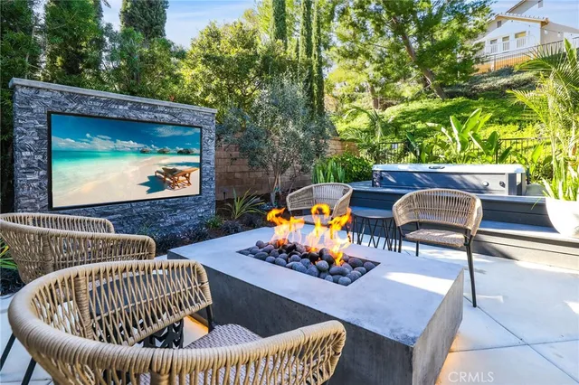 a view of a patio with couches table and chairs with potted plants and a fountain